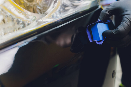 汽车细节男子应用纳米保护涂层的汽车。选择性聚焦。