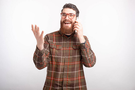 兴奋的大胡子男人一边打电话一边打手势。