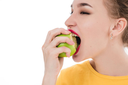 Emotional portrait of a girls who eat an apple on an isolated wh