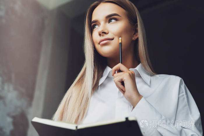 学生正在准备研讨会在笔记本上写笔记美女拿着笔记本用铅笔写笔记