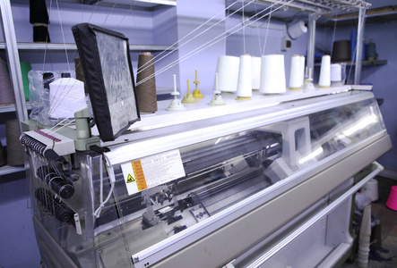 新织布机缝纫车间背景上的粉红色线轴.服装工业.纺织工业用机器.