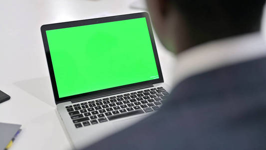 一位非洲商人在看彩色键屏笔记本电脑