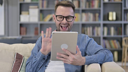 快乐的年轻设计师在平板电脑上进行视频聊天