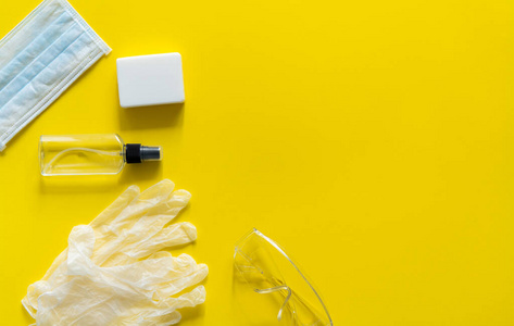 医用防护口罩呼吸机ffp肥皂橡胶手套抗菌剂和防护眼镜均置于黄色背景上。抗covid19病毒保护试剂盒。2019年冠状病