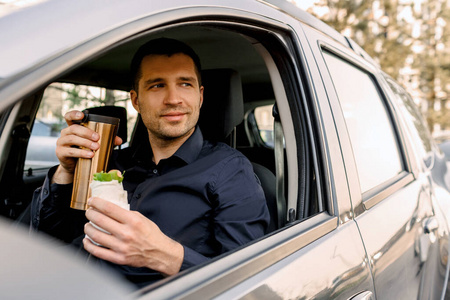 停下来吃点东西。男人在车里吃零食，喝咖啡或茶。