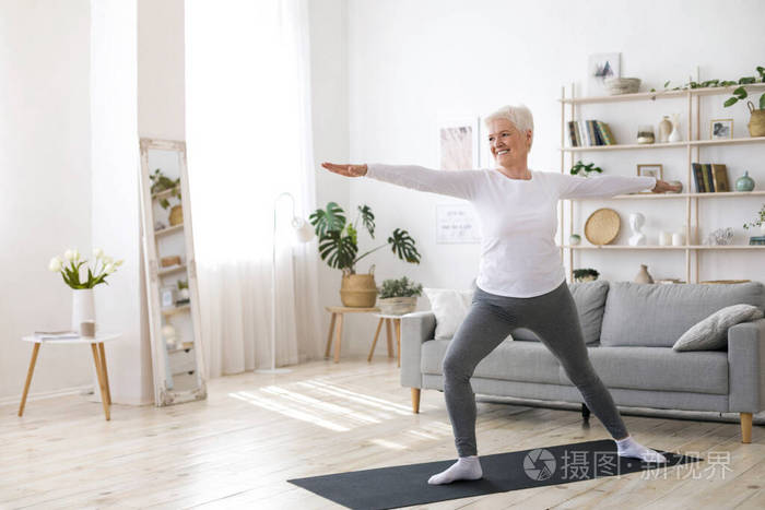 退休运动活跃的老年妇女在家做普拉提训练