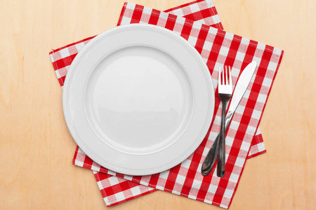 Empty plate and towel over wooden table background. Close up.