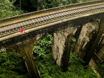 Girl in pink sit on the Rail Road Bridge. Nine Arch Bridge. Sri 