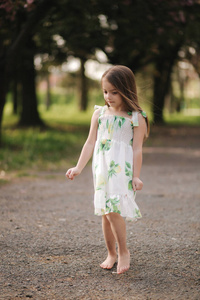 走在池塘里可爱的小女孩光着脚走在外面.公园里有新鲜空气.