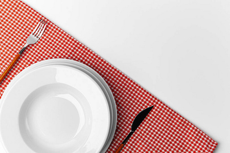 餐叉,刀和餐盘放在毛巾上.孤立的白色背景.照片