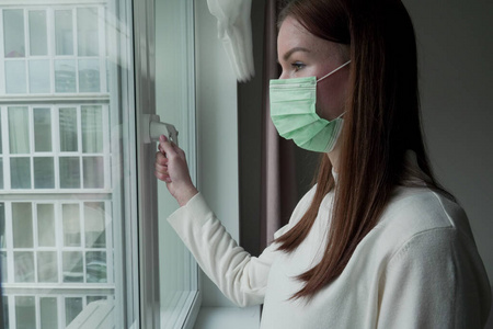女孩关上窗户.被隔离的女孩想念她的家人照片