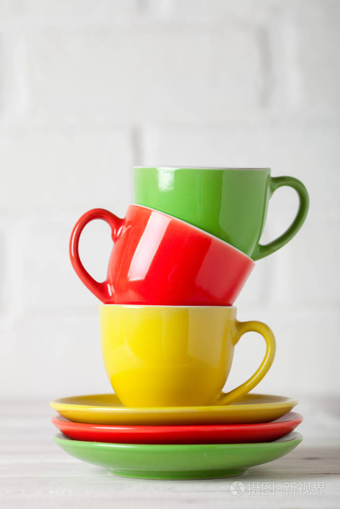 白色背景砖墙上的彩色杯子带复制空间的背景选择性聚焦垂直的
