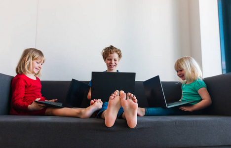 孩子们呆在家里，男孩和女孩用电脑远程学习