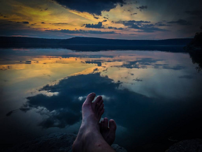 选择在日落或日出时在室外湖边的腿部进行休闲旅行和度假