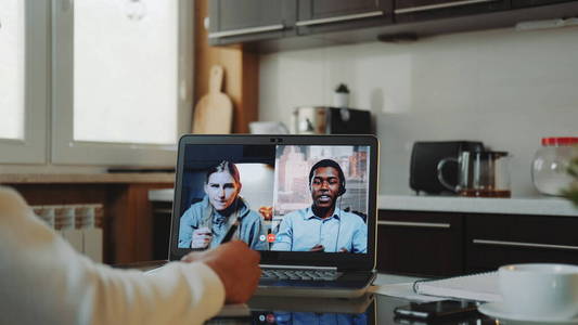 多种族同事在家里通过电脑进行普通视频通话的特写镜头