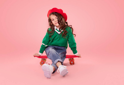 坐在滑板上的时髦小孩照片