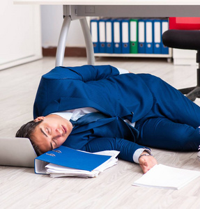 疲惫不堪的商人在办公室加班照片