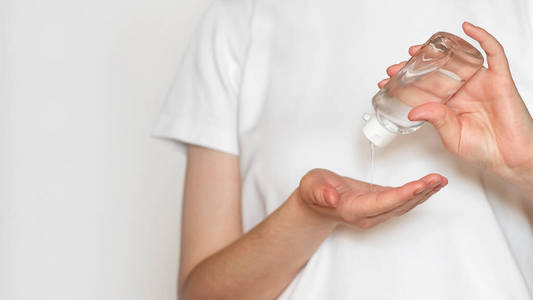 Closeup of woman using antibacterial sanitizer gel in bottle on 