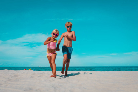 快乐的男孩和女孩在沙滩上奔跑
