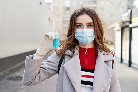 一位年轻的女士,有着漂亮的蓝眼睛和蓬乱的头发,戴着防冠状病毒covid