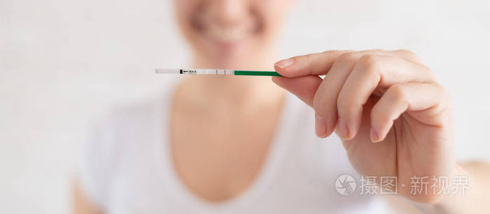 快乐的女人怀孕测试呈阳性女性生育的概念人绒毛膜促性腺激素两条条纹