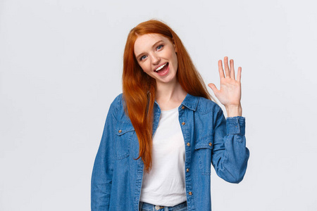 友好,开朗,外向可爱的红发女孩挥舞着手掌,打招呼,问候团队成员,歪着