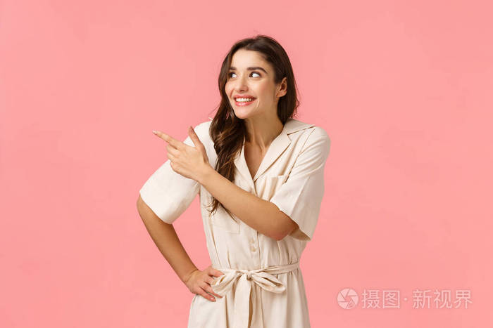 兴高采烈的欧洲黑发女子穿着礼服跃跃欲试,指着左上角,笑嘻嘻的,站在