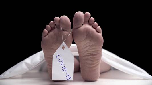 脚趾上贴着标签的脚,身份标签,白纸特写太平间里死去的男人们的脚一具