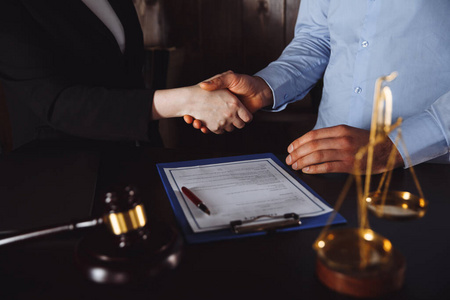 商人和他的合伙人律师或律师在讨论合同协议时握手盖章