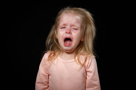 一个小女孩在黑暗的房间里歇斯底里地哭.她受了重伤.照片