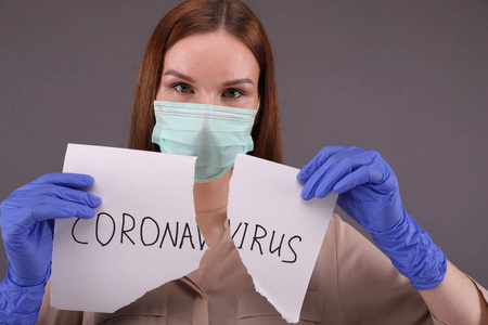 Nurse tears sheet of paper with sign coronavirus