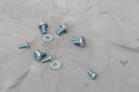 Metal screws, bolts, washers and nuts isolated on gray backgroun