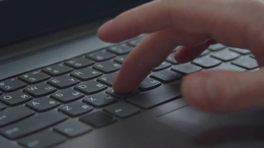一个男人正在笔记本电脑上打字。特写镜头