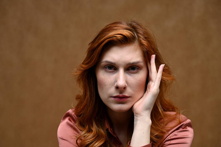 女主角白种人的画像,红头发,流露出严肃的情绪.