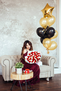 A girl in a beautiful dress with a big bouquet with red and whit