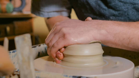 职业男陶工在陶轮上用粘土工作