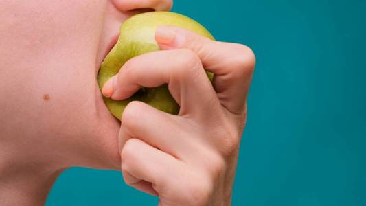 年轻美女咬苹果特写图片