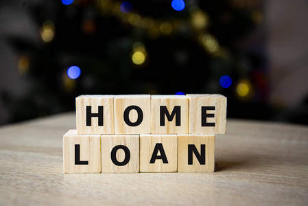 木头背景上带有单词home loan和home model的字母块