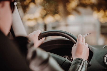欧美开车司机女司机开车时手在车内抽烟的特写镜头照片