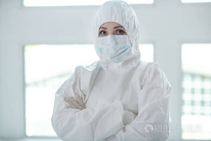 身穿防护服戴医用面罩的医务人员双臂交叉站立