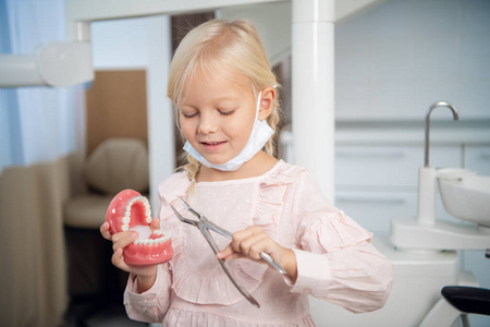 一个可爱的小女孩在诊所里扮演牙医