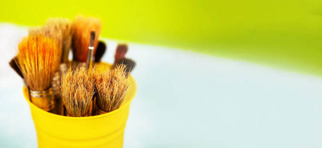 画笔一套用来画颜料的刷子。黄色金属架上有许多刷子