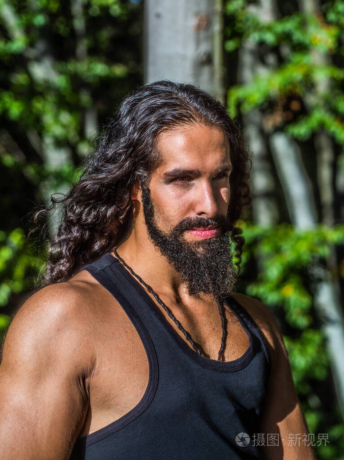 长着黑长发,长着胡须的英俊男子.性感胡子模特.男人的时尚和风格概念.