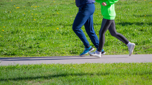 在公园里慢跑的跑步者的脚