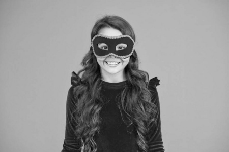 小女孩戴着威尼斯面具微笑.新年晚会.假日季节.圣诞快乐.新年快乐照片