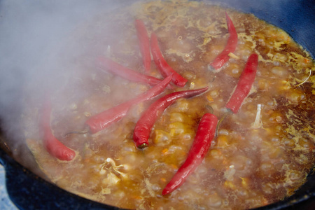 乌兹别克民族菜皮拉夫皮劳普罗夫大锅肉饭。锅里着火的烹调过程。准备阶段。倒出米饭，加入水，红辣椒和整个大蒜