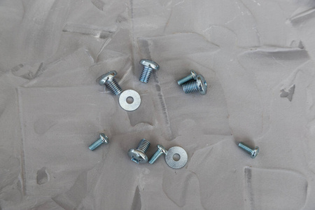 Metal screws, bolts, washers and nuts isolated on gray backgroun
