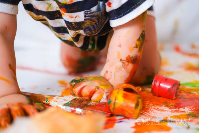 矮胖活泼肮脏的婴儿爬在地板上玩油漆脏小子特写快乐快乐在家玩耍