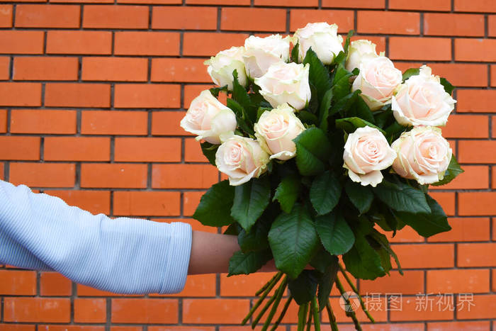 他手里拿着一束奶油玫瑰女士鲜花礼品