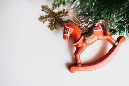 Christmas tree branches decorated with toys snowflake and horse.